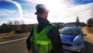 Zdjęcie przedstawia umundurowanego policjanta ruchu drogowego na granicy polsko-białoruskiej.