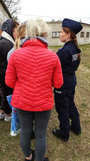 Zdjęcie przedstawia policjantkę rozmawiającą z grupką osób z Ukrainy.