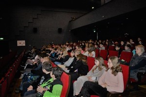 Zdjęcie przedstawia zgromadzona w sali kinoteatru młodzież.