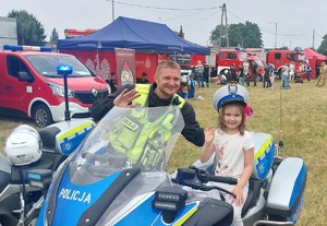Policjanta z dzieckiem siedzącym na motocyklu