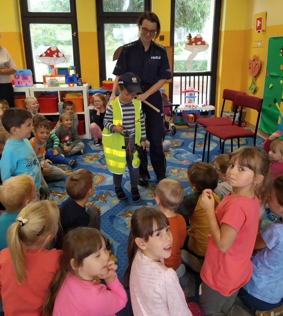 przedszkolak przymierza policyjną kamizelkę odblaskową