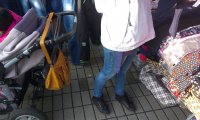 Kobieta podczas zakupów ma otwarta torebkę zawieszona na wózku