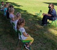 policjantka w ogrodzie przedszkole opowiada dzieciom o zsawodzie policjanta