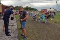 Komendant Powiatowy Policji w Strzelcach Opolskich wręcza nagrody i gratuluje zwycięzcom konkursu oraz ich rodzicom.