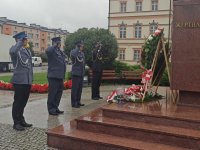 Przedstawiciele służb mundurowych składają kwiaty pod pomnikiem.