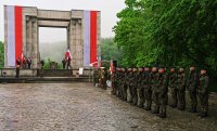 Zdjęcie przedstawia żołnierzy na tle Pomnika Czynu Powstańczego.