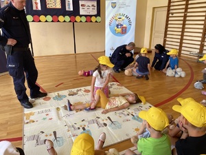 Zdjęcie przedstawia przedszkolaków, uczących się pierwszej pomocy.