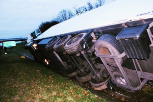 Zdjęcie przedstawia ciężarówkę, przewróconą na prawym boku na autostradzie A4.