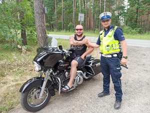 Zdjęcie przedstawia policjanta podczas kontroli motocyklisty.