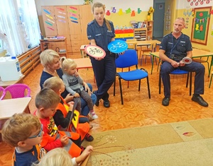 Zdjęcie przedstawia policjantów podczas rozmowy z dziećmi.