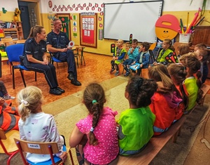 Zdjęcie przedstawia policjantów podczas rozmowy z dziećmi.