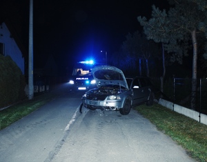 Zdjęcie przedstawia pojazd, który wjechał w ogrodzenie posesji.