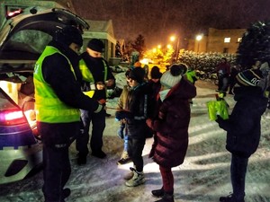 Zdjęcie przedstawia policjantów rozdających odblaski.