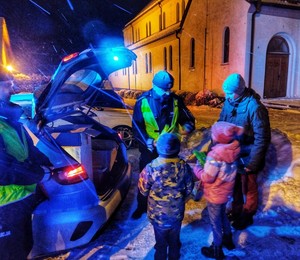 Zdjęcie przedstawia policjantów rozdających odblaski.