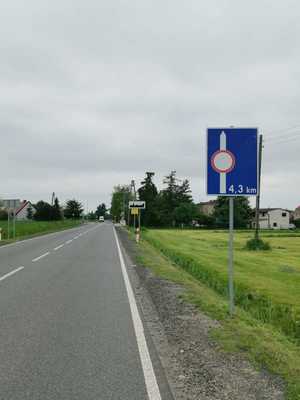 Zdjęcie przedstawia znaki drogowe oraz jezdnię.