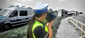 Zdjęcie przedstawia policjantkę kontrolującą prędkość jadących pojazdów.