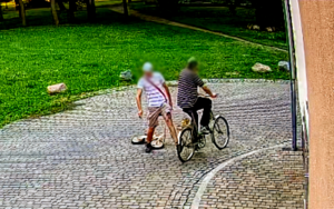 Zdjęcia przedstawia mężczyznę, który kopie w rower rowerzysty
