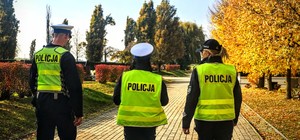 Zdjęcie przestawia policjantów kontrolujących cmentarz.