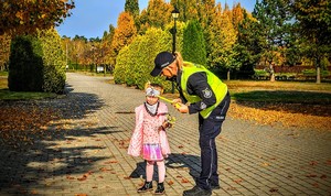 Zdjęcie przestawia policjantów kontrolujących cmentarz.