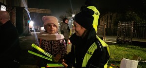 Zdjęcie przedstawia działania profilaktyczne, podczas których Burmistrz Zawadzkiego wraz z policjantami rozdawał mieszkańcom odblaski.