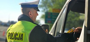 Zdjęcie kolorowe przedstawiające policjanta kontrolującego trzeźwość.
