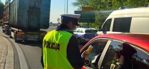 Zdjęcie kolorowe przedstawiające policjanta kontrolującego trzeźwość.