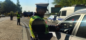 Zdjęcie kolorowe przedstawiające policjanta kontrolującego trzeźwość.
