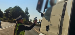 Zdjęcie kolorowe przedstawiające policjanta kontrolującego trzeźwość.