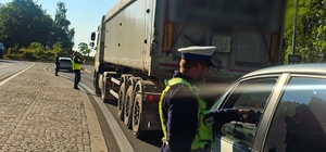 Zdjęcie kolorowe przedstawiające policjanta kontrolującego trzeźwość.