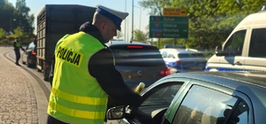 Zdjęcie kolorowe przedstawiające policjanta kontrolującego trzeźwość.