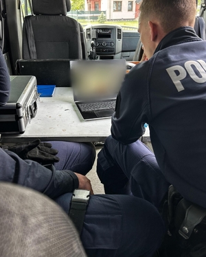 Policjanci analizują nagranie z monitoringu.
