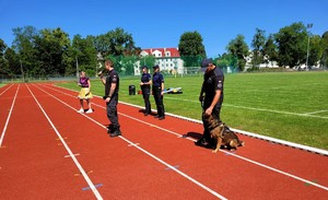 Zdjęcie kolorowe przedstawiające policjantki oraz funkcjonariuszy Służby Więziennej z psem służbowym.