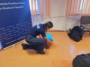 Zdjęcie kolorowe przedstawiające policjantów z dziećmi  w komendzie.