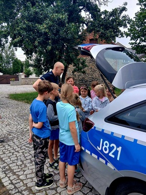 Zdjęcie kolorowe przedstawiające policjantów z dziećmi na spotkaniu edukacyjnym.