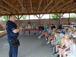 Zdjęcie kolorowe przedstawiające policjantów z dziećmi na spotkaniu w ramach programu "Kręci mnie bezpieczeństwo w lecie".