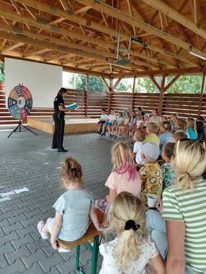 Zdjęcie kolorowe przedstawiające policjantów z dziećmi na spotkaniu w ramach programu "Kręci mnie bezpieczeństwo w lecie".