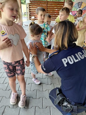 Zdjęcie kolorowe przedstawiające policjantów z dziećmi na spotkaniu w ramach programu "Kręci mnie bezpieczeństwo w lecie".