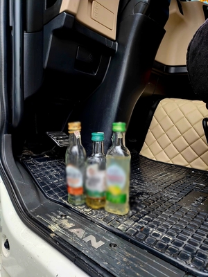 Zdjęcie kolorowe przedstawiające puste butelki po alkoholu w kabinie pojazdu ciężarowego.