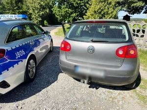 Zdjęcie kolorowe przedstawiające pojazd volkswagen oraz radiowóz.