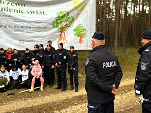 Zdjęcie przedstawia wydarzenie związane z jubileuszem 100-lecia dzielnicowych, którzy z tej okazji posadzili symboliczne 100 sadzonek w lesie.