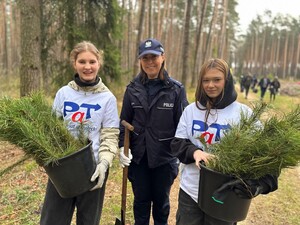 Zdjęcie przedstawia wydarzenie związane z jubileuszem 100-lecia dzielnicowych, którzy z tej okazji posadzili symboliczne 100 sadzonek w lesie.