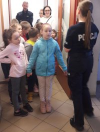 POLICJANTKA POKAZUJE POMIESZCZENIA KOMENDY