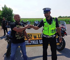 Zdjęcie przedstawia policjanta ruchu drogowego oraz motocyklistę.