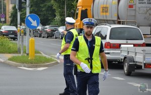 dwóch policjantów ruchu drogowego na skrzyżowania, jeden odchodzi drugi kieruje ruchem